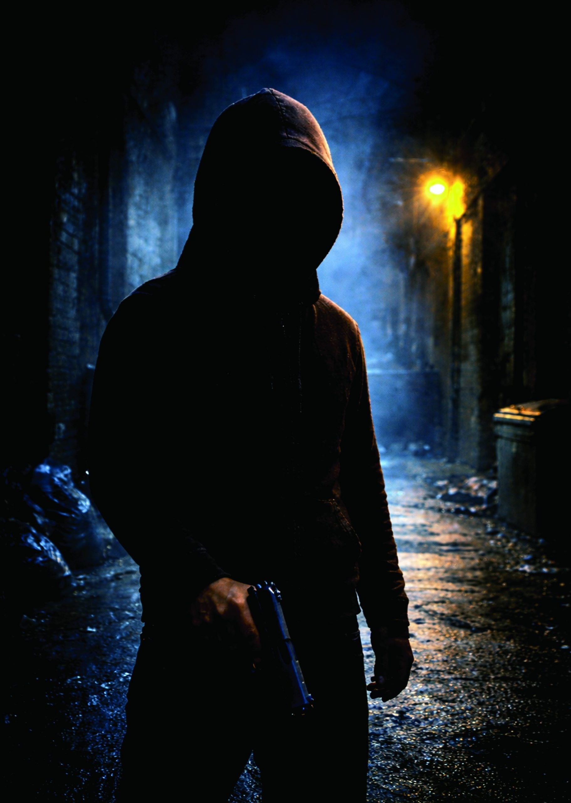 Paul Smith, author of Nine Lives, holding a gun in a dark alley